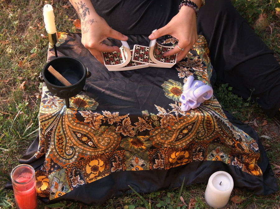 Ritual tools, candle and cards laid out on a cloth