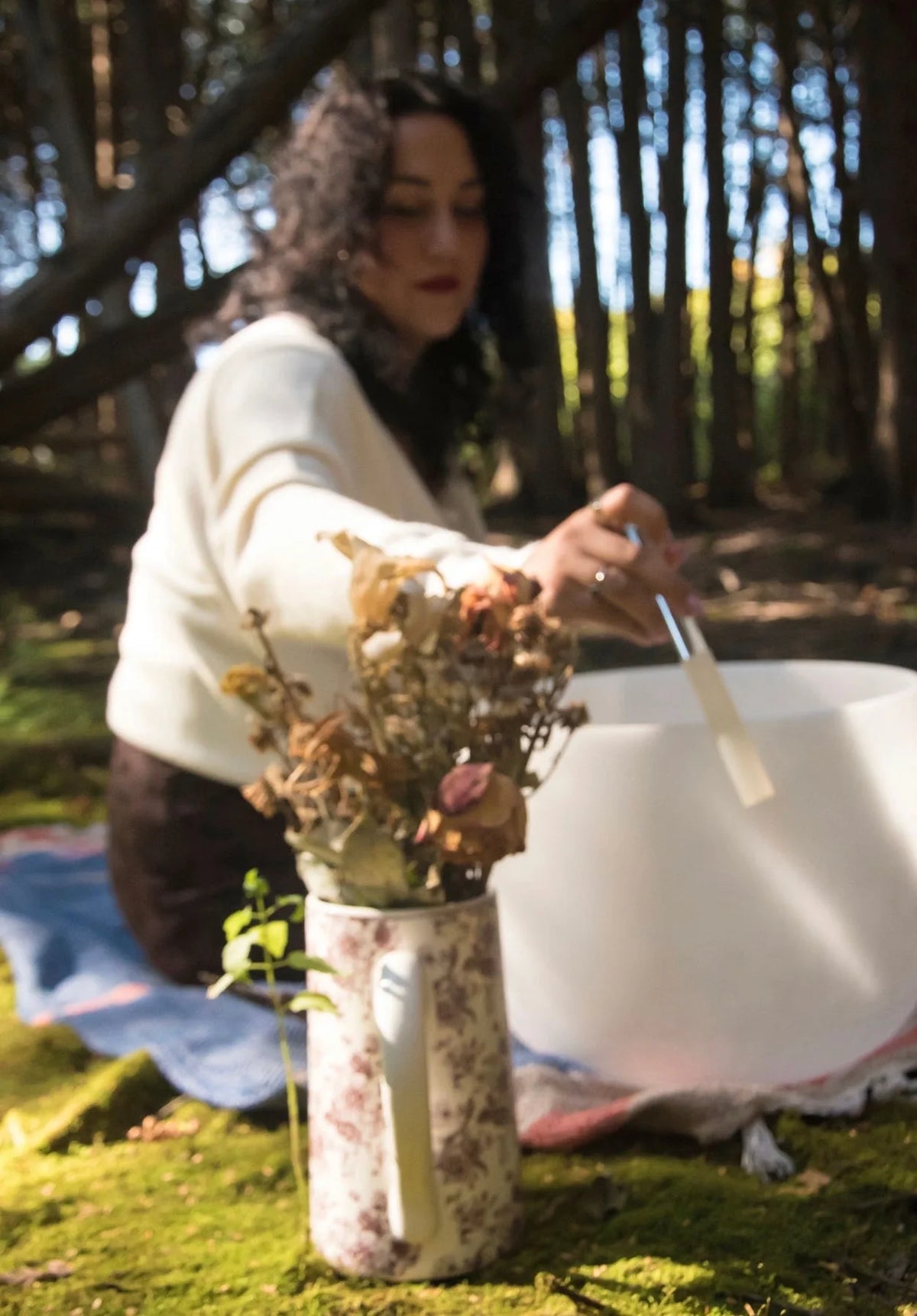 Briaa playing a crystal singing bowl in the forest