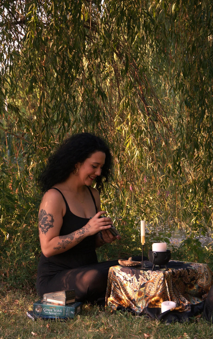 Briaa reading cards outdoors on a patterned cloth